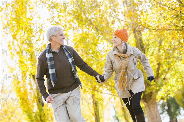 Older Caucasian couple walking near autumn trees