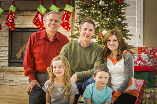 Caucasian multi-generation family smiling in living room at Christmas