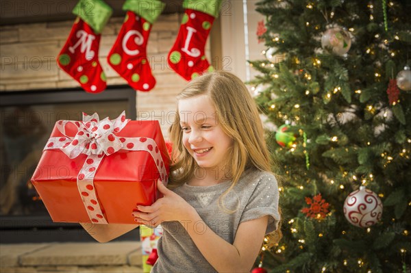 Caucasian girl examining Christmas gift