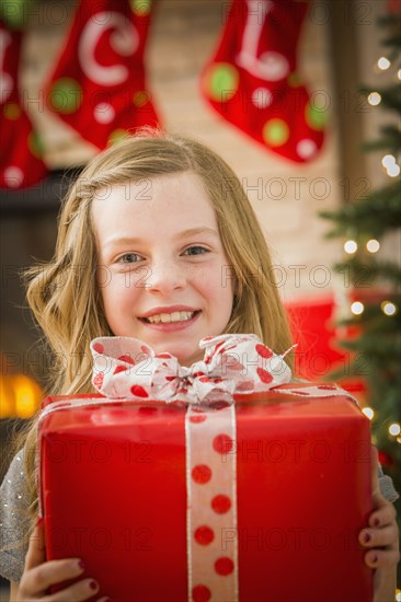 Caucasian girl holding Christmas gift