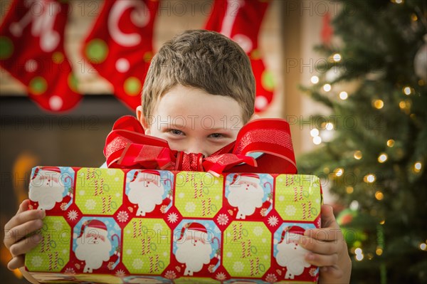 Caucasian boy holding Christmas gift