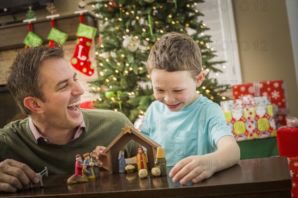 Caucasian father and son arranging nativity at Christmas