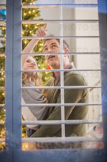 Caucasian father and daughter looking for Santa at Christmas