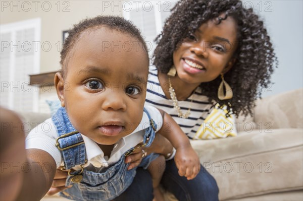 Close up of Black mother holding baby son on sofa