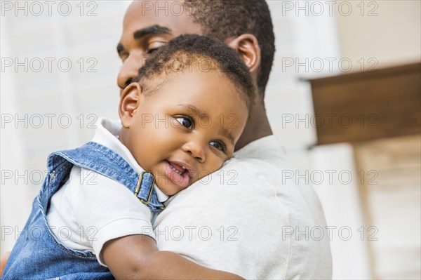 Close up of Black father holding baby son