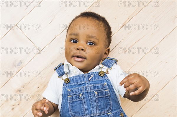 Black baby boy laying on floor