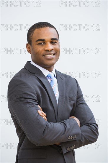 Black businessman smiling with arms crossed