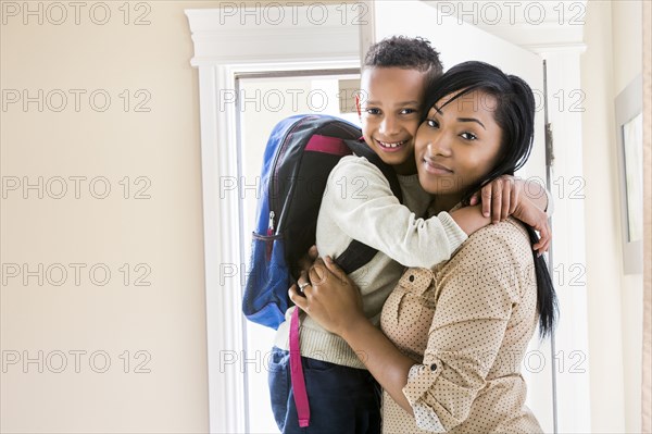 Mother and son hugging at door