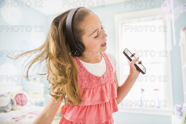 Caucasian girl singing to wireless headphones