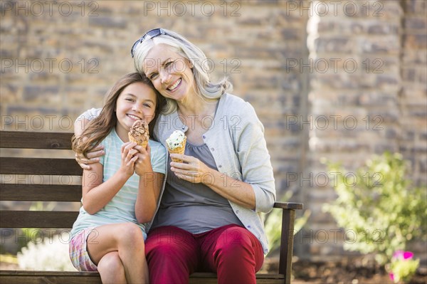 Caucasian grandmother and granddaughter eating ice cream