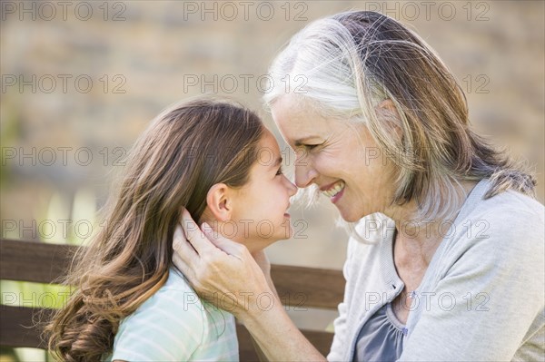 Caucasian grandmother and granddaughter touching noses
