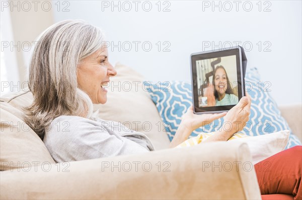 Caucasian grandmother videochatting with granddaughter on digital tablet