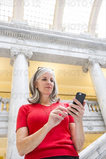 Caucasian businesswoman using cell phone in courthouse