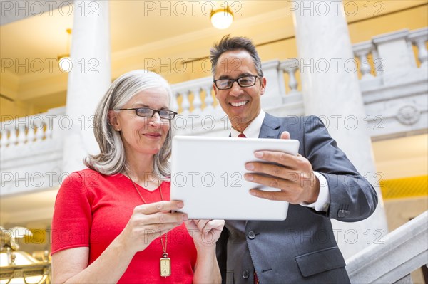 Business people using digital tablet in courthouse