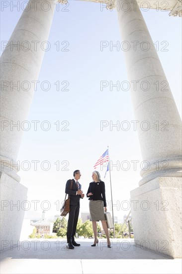 Business people talking under columns