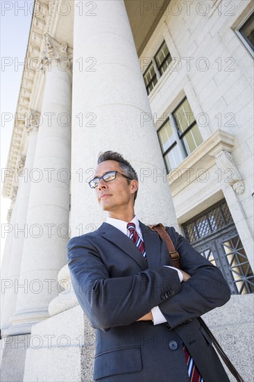 Mixed race businessman standing outside courthouse