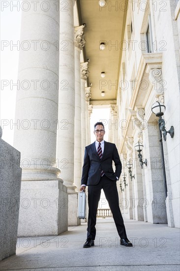 Mixed race businessman standing outside courthouse