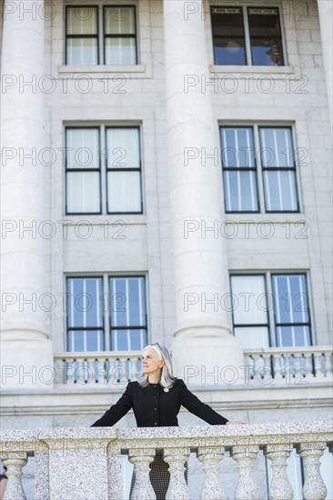 Caucasian businesswoman standing outside courthouse