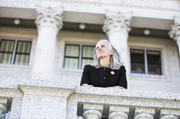 Caucasian businesswoman standing outside courthouse