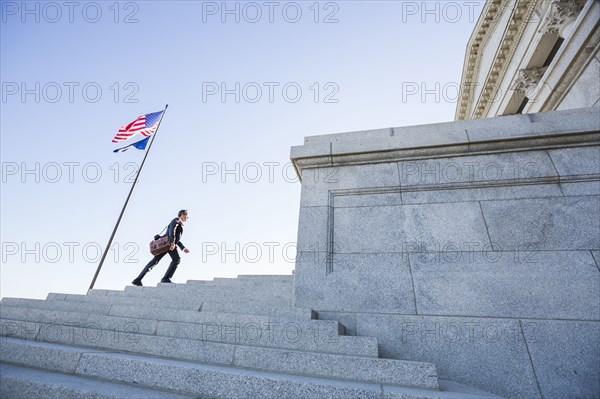 Mixed race businessman walking on courthouse steps