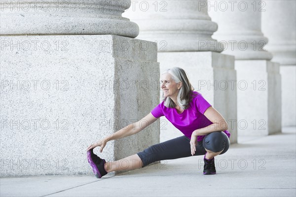 Caucasian woman stretching outside courthouse