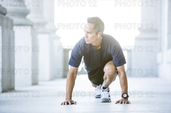 Mixed race man stretching outside courthouse