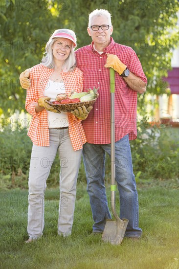 Caucasian couple gardening in backyard