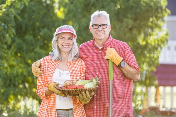 Caucasian couple gardening in backyard