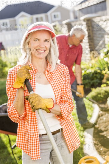 Caucasian couple gardening in backyard