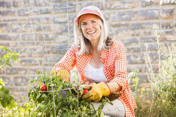 Caucasian woman picking vegetables in garden