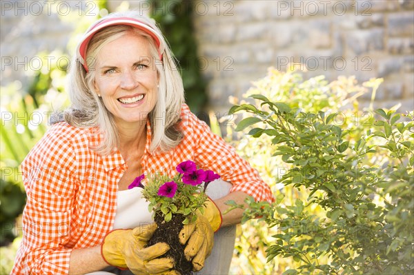Caucasian woman planting flowers in garden