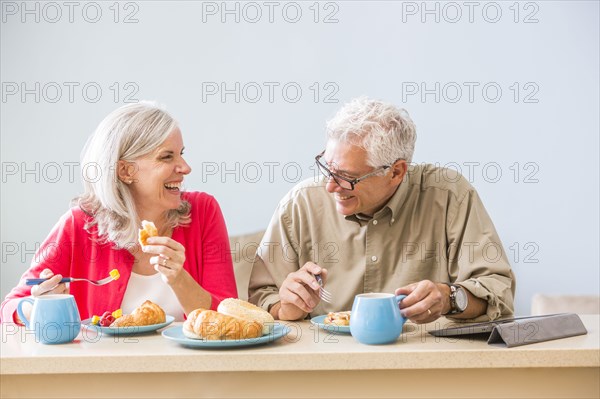 Caucasian couple eating at table