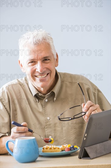 Caucasian man using digital tablet at table