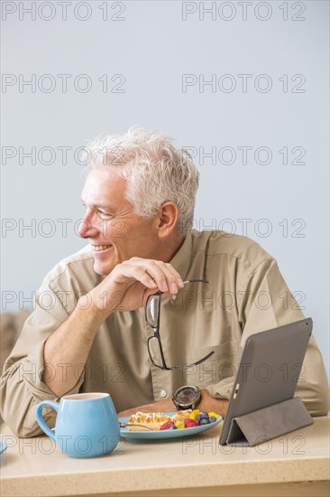 Caucasian man using digital tablet at table