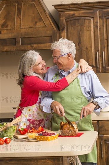 Caucasian couple hugging in kitchen