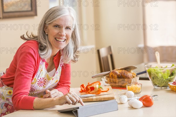 Caucasian woman cooking in kitchen