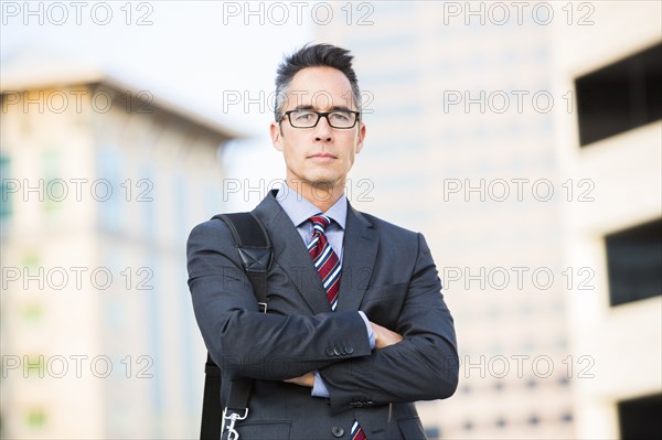 Mixed race businessman standing outdoors