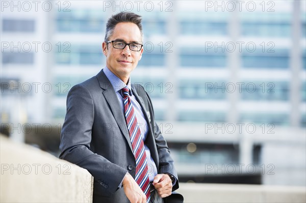 Mixed race businessman standing outdoors