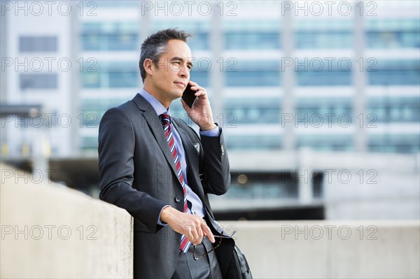 Mixed race businessman talking on cell phone