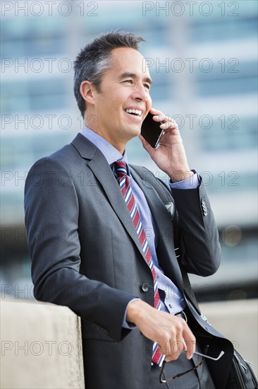 Mixed race businessman talking on cell phone