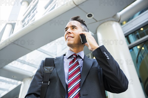 Mixed race businessman talking on cell phone