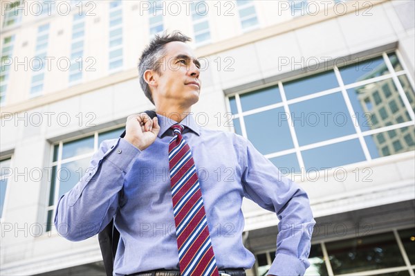 Mixed race businessman standing outdoors