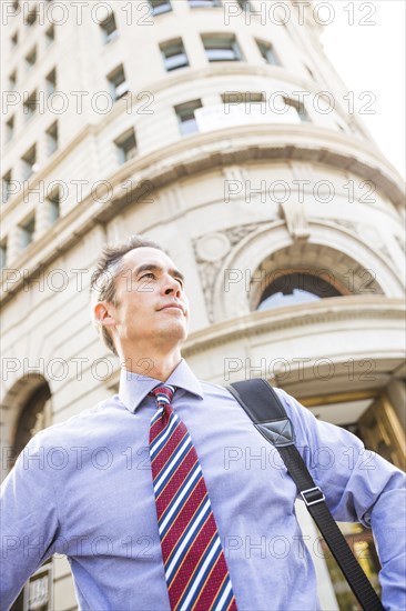 Mixed race businessman standing outdoors