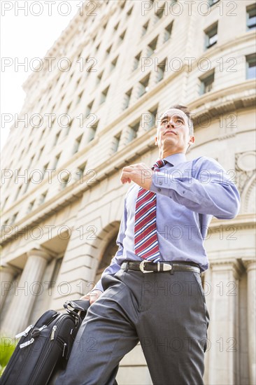 Mixed race businessman walking outdoors