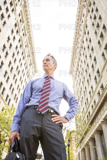 Mixed race businessman standing outdoors