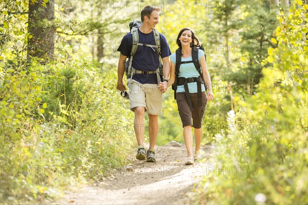 Caucasian couple hiking on path