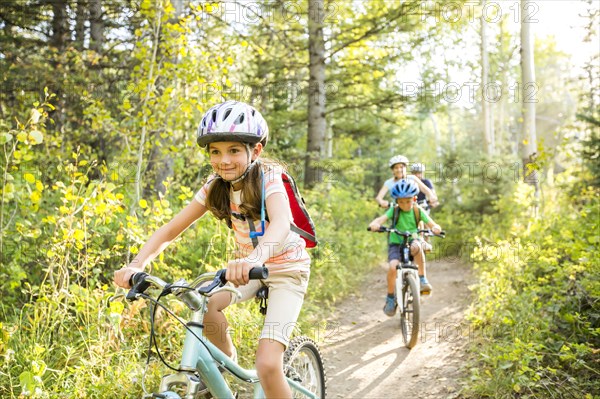 Caucasian family riding mountain bikes