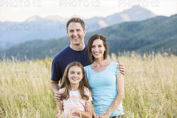 Caucasian family smiling in field