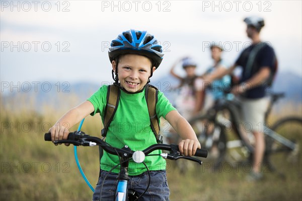 Caucasian boy smiling on mountain bike