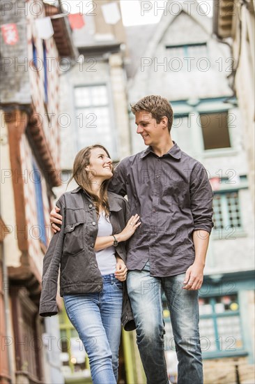 Caucasian couple walking in village